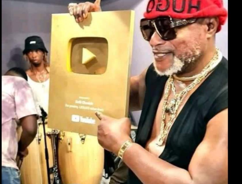 Koffi Olomide brandissant son trophée de créateur d'Or Youtube.
