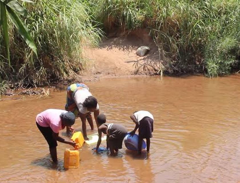 Des jeunes puisant l'eau dans une rivière 